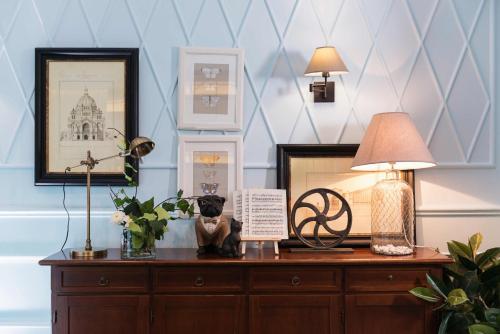 a wooden dresser with a lamp and pictures on it at Areela Boutique Hotel in Tirana