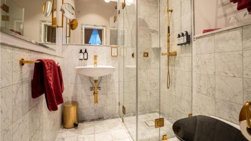 a bathroom with a sink and a shower with a sink at Grand Hotel Lund in Lund
