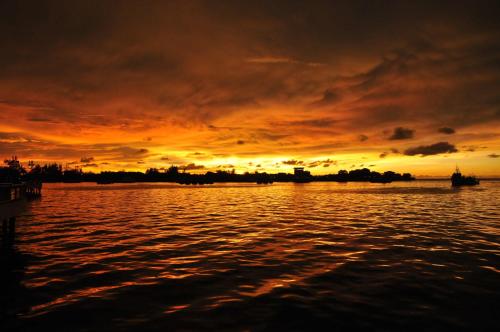 a sunset over a body of water at Api-Api GuestHouse in Kota Kinabalu