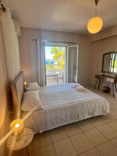 a bedroom with a bed and a large window at Villa Melissani in Karavomylos