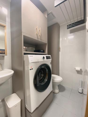 a bathroom with a washing machine and a toilet at AJA Suite in Davao City