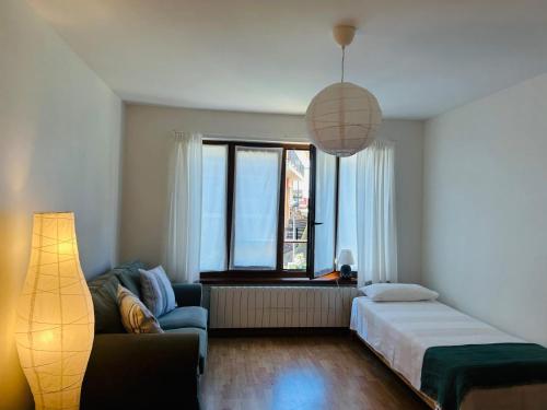 a bedroom with a bed and a couch and a window at Casa de la Tila in Arenas de Cabrales