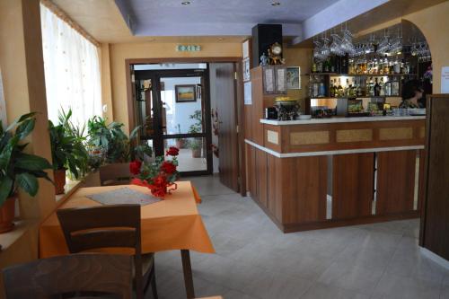 a restaurant with a bar and a table with flowers at Blyan Family Hotel in Chiflik