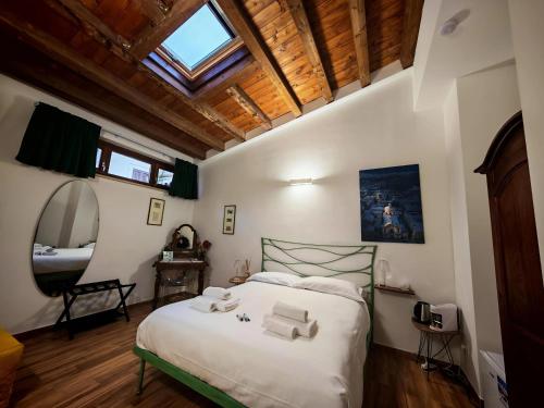 a bedroom with a large white bed with a wooden ceiling at Le Cancelle - Residenza d'epoca in LʼAquila