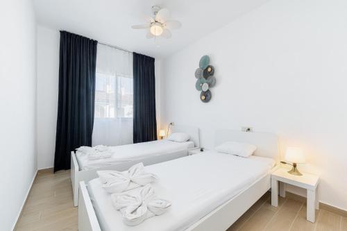 two beds in a white room with a window at Lago Jardin 69 in Los Altos