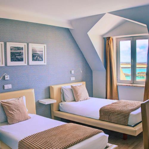 ein Zimmer mit zwei Betten und einem Fenster in der Unterkunft Hotel Nobu Peniche in Peniche