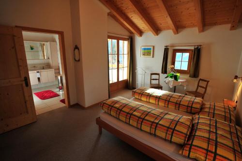 a bedroom with two beds and a living room at Bed & Breakfast La Val in Trin