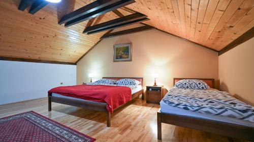 two beds in a bedroom with a wooden ceiling at Villa Requiem by Villas Guide in Bednja