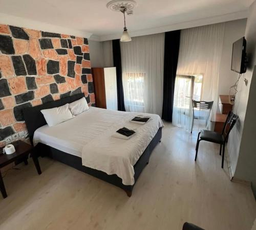 a bedroom with a large bed with a brick wall at mavikumsal otel in Kumburgaz