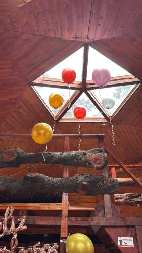 a group of different colored balloons hanging from a ceiling at La Roca Glamping in Arcabuco