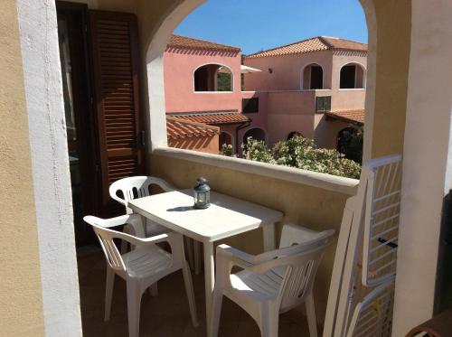 a small white table and chairs on a balcony at Sardinia Beach Apartments in Aglientu