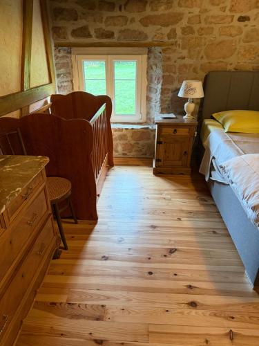a bedroom with a bed and a wooden floor at La maison dans les prés in Labaroche