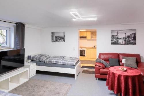 a living room with a bed and a red couch at Am Waldrand in Radis