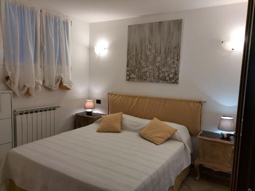 a bedroom with a bed with two pillows on it at Casa Olimpia - Mareri apartments in Poggi