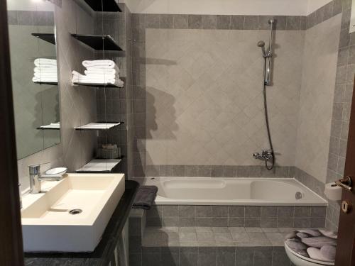 a bathroom with a white tub and a sink at Casa Olimpia - Mareri apartments in Poggi