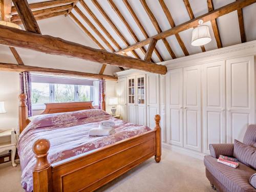 a bedroom with a wooden bed and a window at 1 Bed in Thetford oc-57889 in Saham Toney