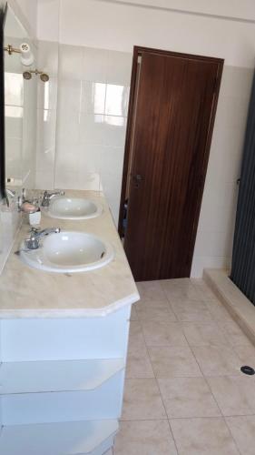 a bathroom with two sinks and a brown door at Cozy rooms in Minde, Fatima in Minde