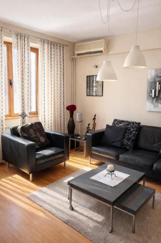a living room with a black couch and a table at Sim apartment in Skopje in Skopje