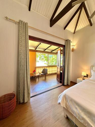 a bedroom with a bed and a living room at Holiday Beach Hotel in Nosy Be