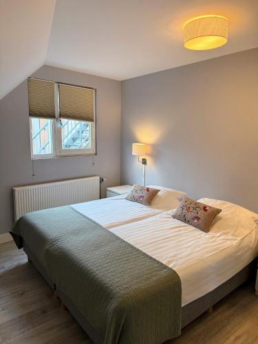 a bedroom with a large bed with two pillows at Residence Le Mistral in Noordwijk aan Zee