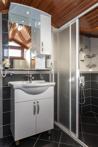 a bathroom with a white sink and a shower at Gokcen Hotel & Apartments in Oludeniz