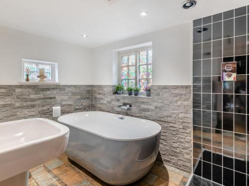 a bathroom with a bath tub and a sink at 1 Bed in Gainsborough oc-66230 in Heapham