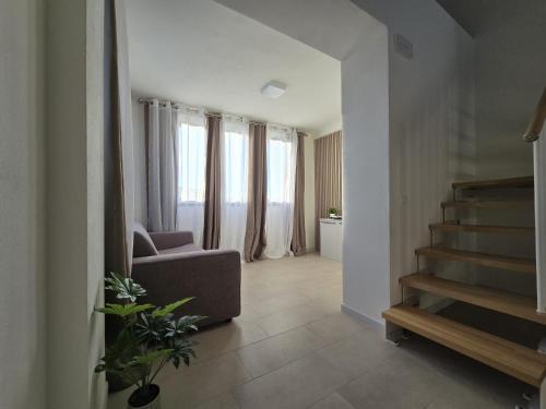 a living room with a couch and a stair case at Salionze Apartments in Salionze