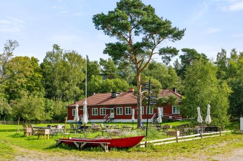 a red boat sitting in front of a house at Haraldsgården Vandrarhem in Blidö