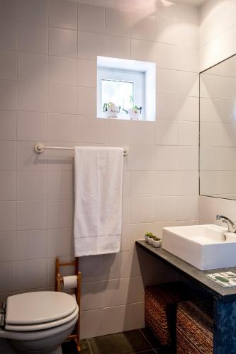 a bathroom with a white toilet and a sink at WABI SABI-QuintAlão in Passô