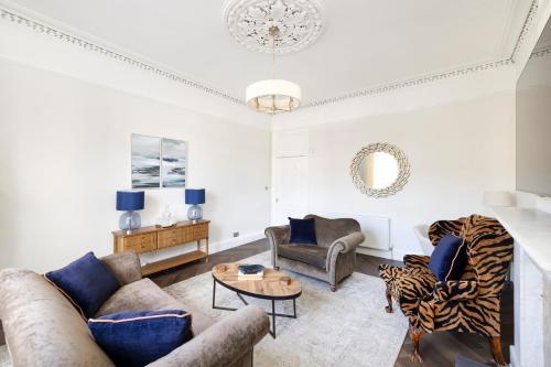 a living room with couches and a table at JOIVY Family Flat near Leith in Edinburgh