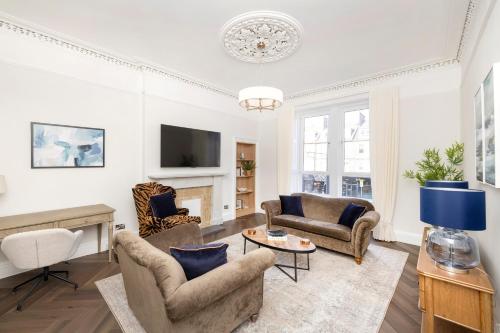 a living room with two chairs and a fireplace at JOIVY Family Flat near Leith in Edinburgh