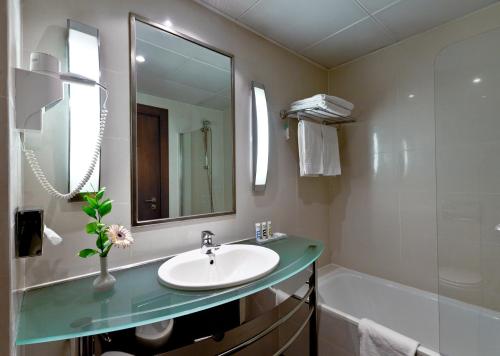 a bathroom with a sink and a bath tub at Hotel Mercure Lisboa in Lisbon