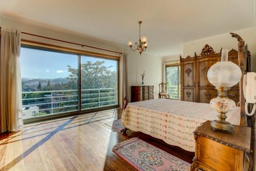 a bedroom with a bed and a large window at Lagos House in Braga
