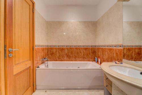 a bathroom with a tub and a sink at Lagos House in Braga