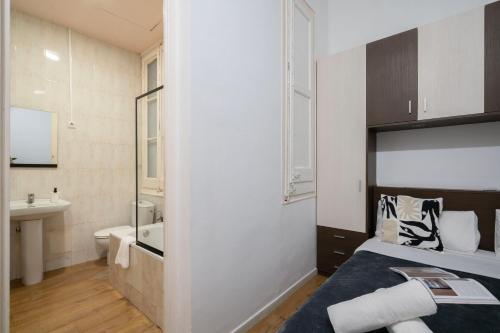 a small bathroom with a bed and a sink at Hostal Sant Antoni in Barcelona