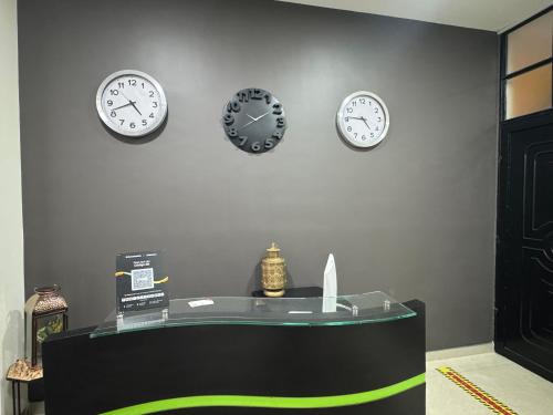 four clocks are on a wall above a counter at Tu Hotel Chía in Chía