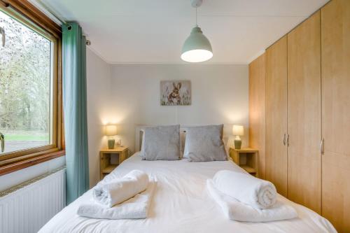 a bedroom with a large white bed with towels on it at Athelington lodge - Beech in Eye