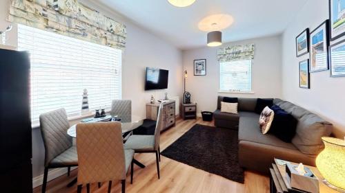 a living room with a couch and a table at The Puffin Pad - Part of the The Bay Filey Holiday Village with pool, gym and direct beach access, pub, restaurant, tennis and meadows walks in Filey
