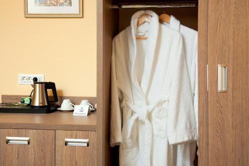 a robe hanging on a door in a hotel room at GRAND OTRADA Hotel Resort & SPA in Odesa