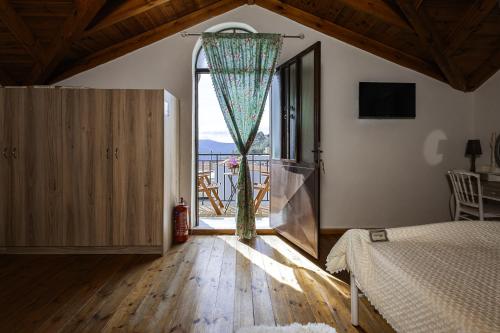 a bedroom with a bed and a large window at Manoli's Light Stone House in Vathi