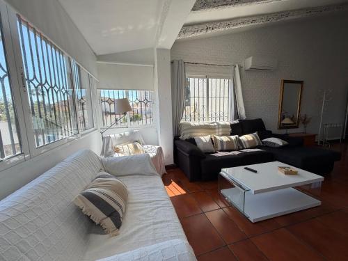 a living room with a couch and a table at Villa puerto marina beach in Benalmádena
