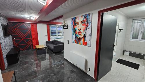 a waiting room with a large painting on the wall at La Suite Rouge Proche Paris & Stade De France in Drancy