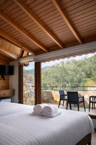 a bedroom with a bed and a large window at Gokyuzu Hotel in Edremit