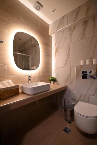 a bathroom with a sink and a toilet and a mirror at Efanton 3 in Larisa