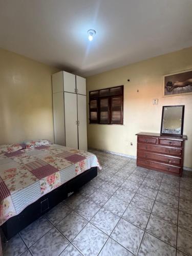 a bedroom with a bed and a dresser in it at Casa de Temporada in Caucaia