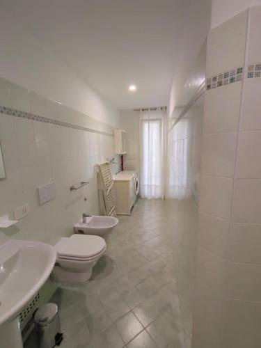 a white bathroom with two toilets and a sink at Oasi del Sole in Cupra Marittima