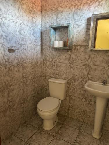 a bathroom with a toilet and a sink at Casa de Temporada in Caucaia