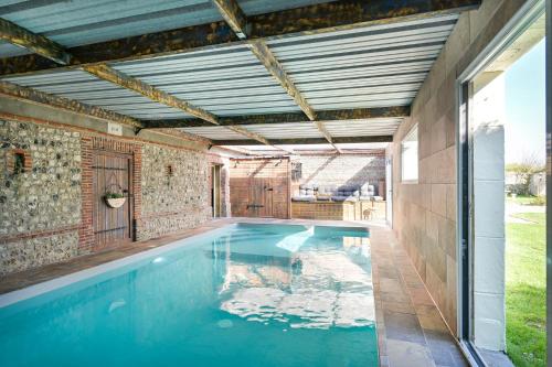 una piscina cubierta con patio y casa de piscina en L'Orée d'Etretat, en La Poterie-Cap-dʼAntifer