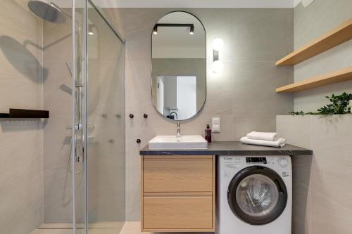 a bathroom with a washing machine and a mirror at GRANO FLATS Trimare Sztutowo in Sztutowo