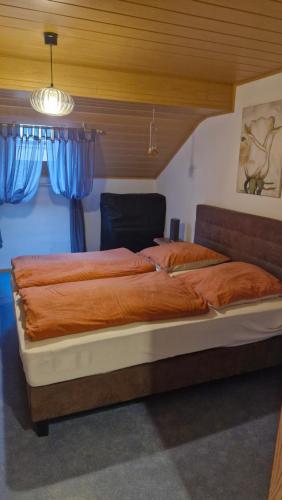 a large bed in a bedroom with blue curtains at Martina in Saint-Vith
